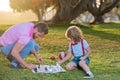 Happy family outdoor. Clever concentrated and thinking smart child playing chess. Father and son playing chess in summer Royalty Free Stock Photo