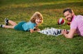 Happy family outdoor. Father and son playing chess in spring garden. Child learning to play chess. Little boy think or Royalty Free Stock Photo