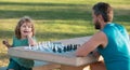 Happy family outdoor. Father and son playing chess in summer garden. Games and activities for children. Royalty Free Stock Photo