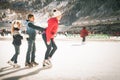 Happy family outdoor ice skating at rink. Winter activities Royalty Free Stock Photo