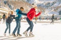 Happy family outdoor ice skating at rink. Winter activities Royalty Free Stock Photo