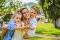 Happy family outdoors on the grass in a park, smiling faces, having fun Royalty Free Stock Photo