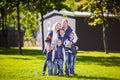 Happy Family Outdoors. Happy Caucasian family standing outside their house and hugging. Family with four children in front house.