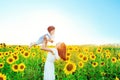 Happy family outdoors. Mother throws baby up, laughing and playing in the sunflowers field in summer on the nature Royalty Free Stock Photo