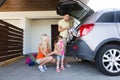 Happy family packing things to car at home parking Royalty Free Stock Photo