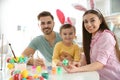 Happy family painting Easter eggs in kitchen Royalty Free Stock Photo