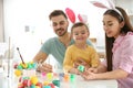 Happy family painting Easter eggs in kitchen Royalty Free Stock Photo