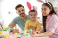 Happy family painting Easter eggs in kitchen Royalty Free Stock Photo