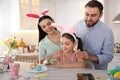 Happy family painting Easter eggs at table in kitchen Royalty Free Stock Photo