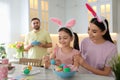 Happy family painting Easter eggs at table indoors Royalty Free Stock Photo