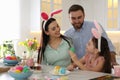 Happy family painting Easter eggs at table in kitchen Royalty Free Stock Photo