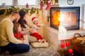 happy family father mother and children sitting by fireplace on Christmas Eve Royalty Free Stock Photo