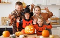 Happy family parents and kids does scary gesture, while make jack-o-lantern from pumpkin, getting ready for halloween Royalty Free Stock Photo