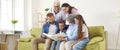 Happy family parents, kids, grandparents look at family photo album together sit in living room. Royalty Free Stock Photo