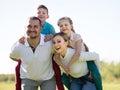 Children riding their parents in the park Royalty Free Stock Photo