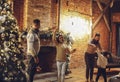 Happy family parents with two kids dancing near fireplace on cozy Christmas Eve in countryhouse