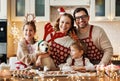 Happy family parents with two kids and golden retriever puppy while making xmas cookies at home Royalty Free Stock Photo