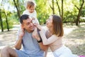 Happy family in the park. The lights of a sun. Mom, dad and baby happy walk at sunset. The concept of a happy family Royalty Free Stock Photo