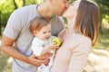 Happy family in the park. The lights of a sun. Mom, dad and baby happy walk at sunset. The concept of a happy family Royalty Free Stock Photo