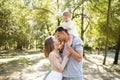 Happy family in the park. The lights of a sun. Mom, dad and baby happy walk at sunset. The concept of a happy family Royalty Free Stock Photo