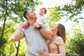 Happy family in the park. The lights of a sun. Mom, dad and baby happy walk at sunset. The concept of a happy family Royalty Free Stock Photo