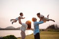 Happy family in the park sunset light. family on weekend playing together in the meadow with river Parents hold the child and Royalty Free Stock Photo