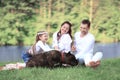 Happy family with pet dog at picnic in a Sunny summer day. pregn Royalty Free Stock Photo