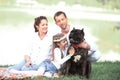 happy family with pet dog at picnic in a Sunny summer day. pregn Royalty Free Stock Photo