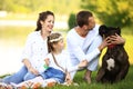 happy family with pet dog at picnic in a Sunny summer day. pregn Royalty Free Stock Photo