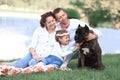 happy family with pet dog at picnic in a Sunny summer day. pregn Royalty Free Stock Photo