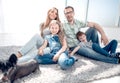 Happy family with pet sitting on the carpet Royalty Free Stock Photo