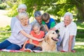 Happy family petting their dog in the park Royalty Free Stock Photo