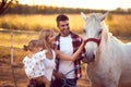 Happy family petting a white horse.  Fun on countryside, sunset golden hour. Freedom nature concept Royalty Free Stock Photo