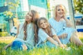 Happy Family photo. Closeup portrait photo toothy smiling two cute girls, her mother three members family just women on grass