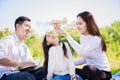 Happy family picnic. Asian parents Father, Mother and daughter playing the toy airplane and have enjoyed ourselves together whil