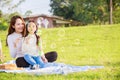 Happy family picnic. A little girl blowing soap bubbles with parents Father, Mother with fun and enjoyed together during Royalty Free Stock Photo