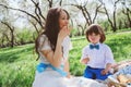 Happy family on picnic for mothers day. Mom and toddler son eating sweets outdoor in spring Royalty Free Stock Photo