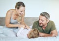 Happy family play and laugh together on the bed having fun at home on a weekend. Playful, love and carefree parents Royalty Free Stock Photo