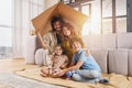 Happy family play together under a cardboard roof