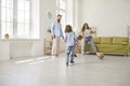 Happy family playing ball and having fun together in living room of their new house Royalty Free Stock Photo