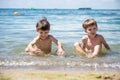 Happy family playing in blue water of swimming pool on a tropical resort at the sea. Summer vacations concept. Two brother kids Royalty Free Stock Photo