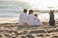 Happy family playing with dog on beach Royalty Free Stock Photo