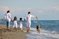 Happy family playing with dog on beach Royalty Free Stock Photo