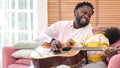 Happy family playing Guitar having fun together with little girl in modern living room. Funny active family carefree little kids