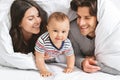 Happy family playing hiding under blanket in bed Royalty Free Stock Photo