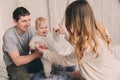 Happy family playing at home on the bed. Lifestyle capture of mother, father and baby Royalty Free Stock Photo