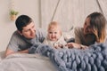 Happy family playing at home on the bed. Lifestyle capture of mother, father and baby Royalty Free Stock Photo