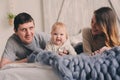 Happy family playing at home on the bed. Lifestyle capture of mother, father and baby Royalty Free Stock Photo