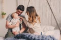 Happy family playing at home on the bed. Lifestyle capture of mother, father and baby Royalty Free Stock Photo