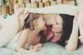 Happy family playing at home. Mother and toddler daughter relaxing and having fun in bed